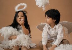 multiethnic children in angel costumes in studio with cotton wool